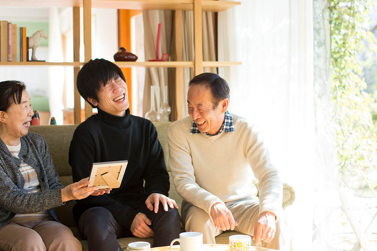 祖父母と写真を見る孫