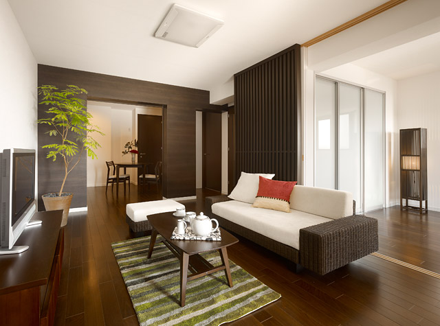 家の中心となるリビング。奥のダイニング・キッチンと右手の居室とも繋がり開放的に。インテリアも含め全体的にダークブラウンで統一された落ち着きある空間に仕上がりました。