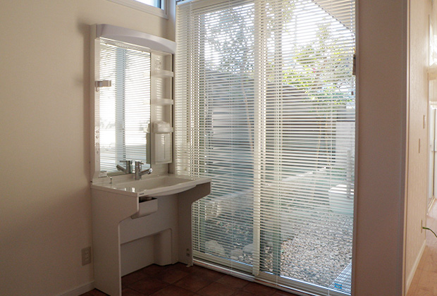親御さんの寝室には車いす対応の洗面。ブラインドからもれる光が心地よい