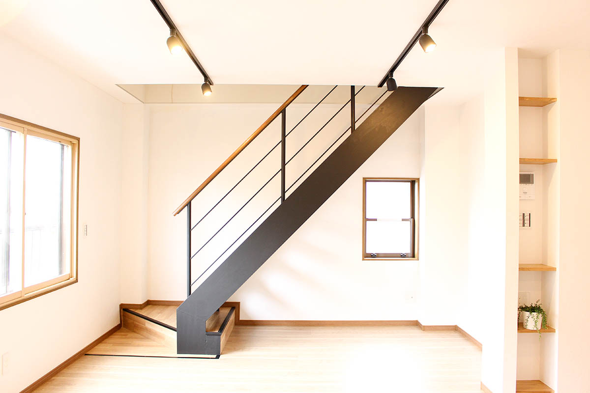 階段after：鉄部はマットな黒色に塗装、踏み板は木目調フロアタイルを貼り、統一感のある空間になりました。