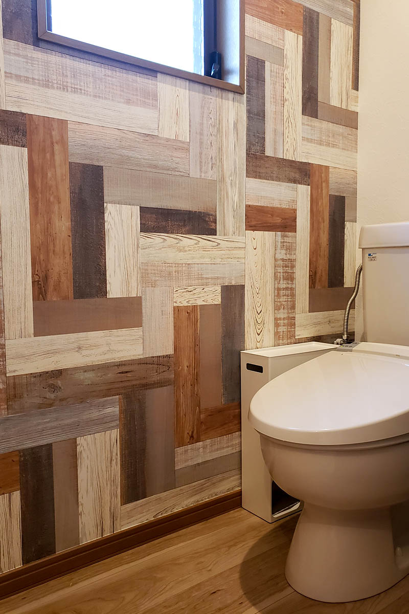 トイレの壁にカラフルなウッド柄の壁紙をチョイス。普段は隠れるからこそ、アクセントクロスで遊ぶのもおススメ。