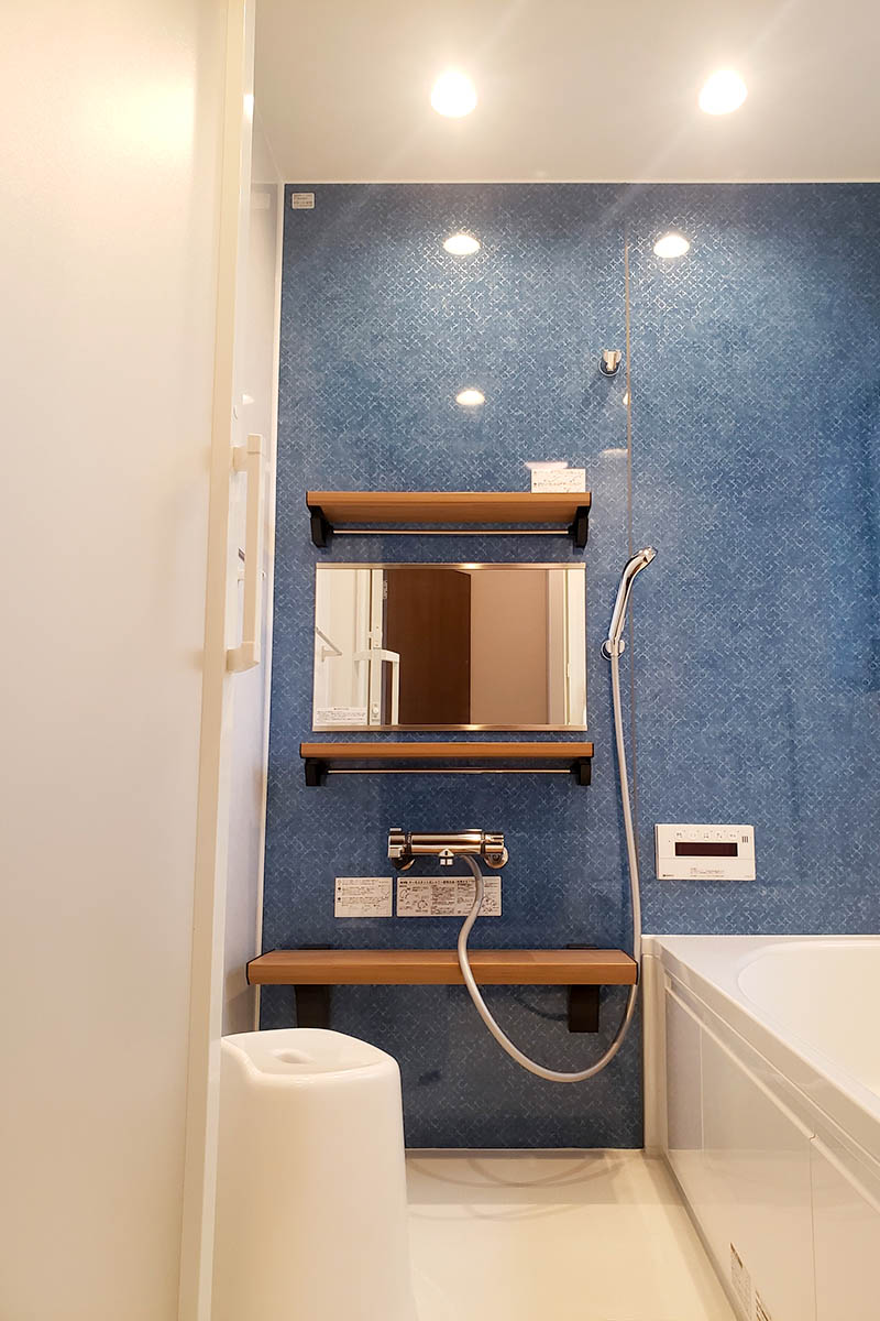 浴室では珍しい青色のアクセントウォールに木目調の棚でおしゃれな空間に。一日の疲れも癒されそうですね。