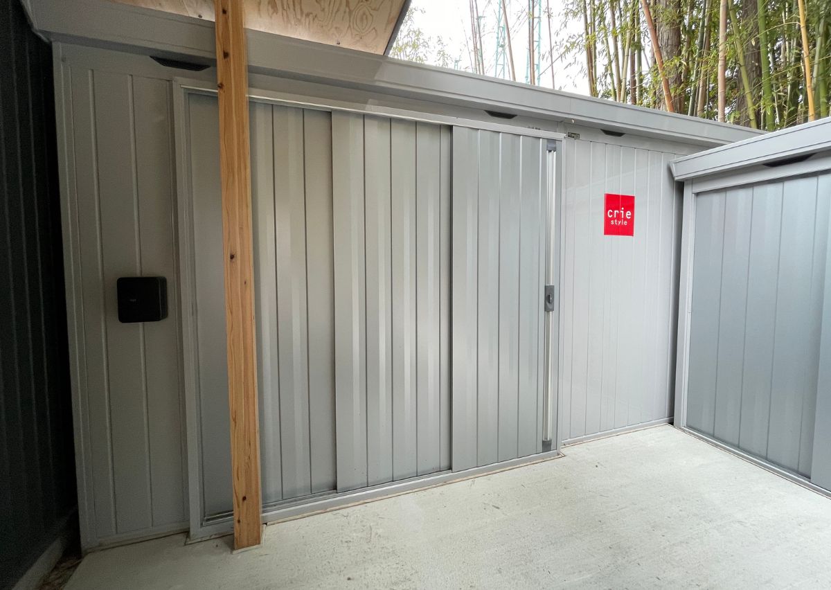 外に約10畳の大型物置を新設。2枚引き戸で大きく開き、工事看板や脚立、イベント用品もたっぷり収納。