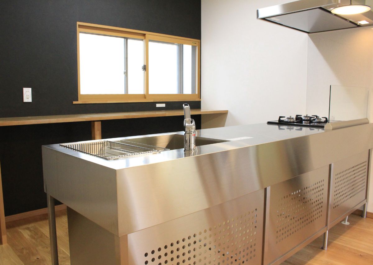 キッチン AFTER｜サンワカンパニーのステンレス製対面キッチンに。無垢の造作棚は、家電も自由に収納可能。