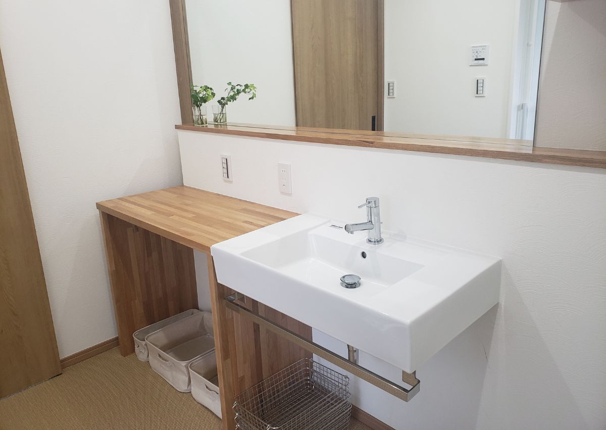 大きな鏡と木の造作カウンターが印象的。3畳の広さがあり、滑りにくい床でお子さまも安心です。
