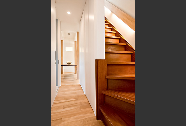 廊下after：天井までの白いハイドアで明るく広々と感じます。階段は既存のまま残し、思い出も蘇ります。