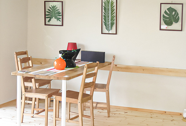 無垢の木のテーブルは壁に取り付けた木のレールで位置を左右にスライドでき、レイアウトもラクラク変えられます。