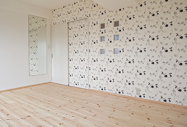 寝室の一面に貼ったアクセントクロスでエモい空間に！壁のガラスブロックから家族の気配も感じられます。