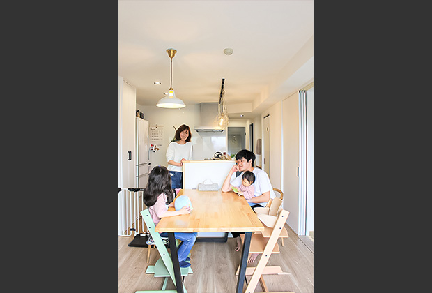 大きな無垢のパイン材のテーブル板に台形の黒いアイアンの脚を取り付けたオリジナル造作テーブルで家族団らん。