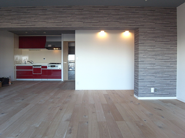 キッチンは既存のまま使用。LDKをしっかり支える構造体の大梁は石積み調のクロスで演出。