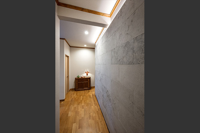 玄関すぐの石貼りの壁。絵等を飾るギャラリーとしても優秀