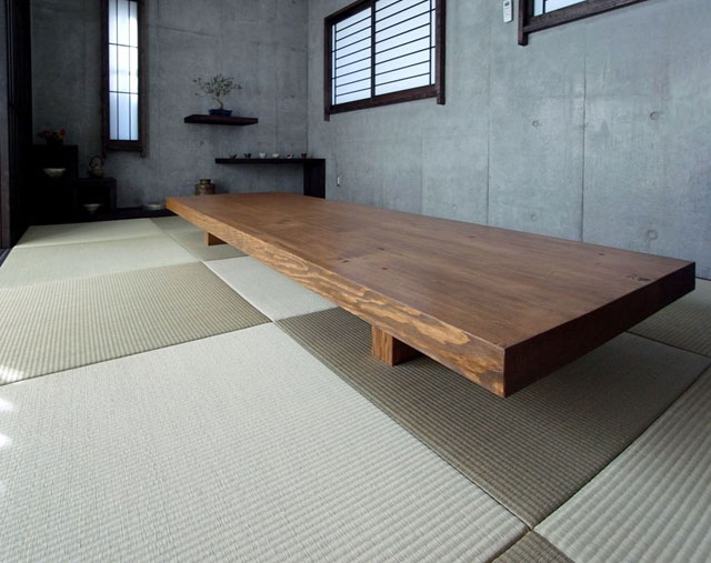 かつての子供部屋のロフトのための構造梁を利用して造った無垢材の大きな座卓