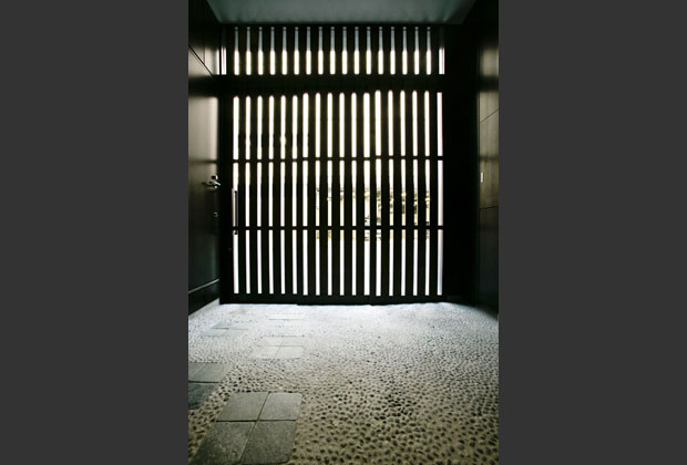 エントランスには防犯用シャッターの代わりに、和の雰囲気を感じる木の格子戸を設けスリットから光を取り込む。