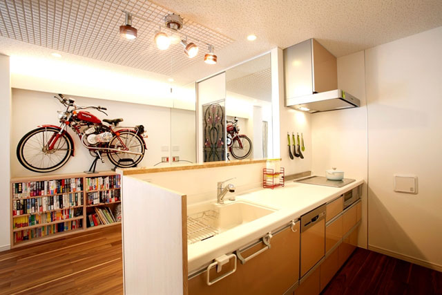 本棚の上にはバイクをディスプレイ。間接照明で柔らかな光が空間を照らします。