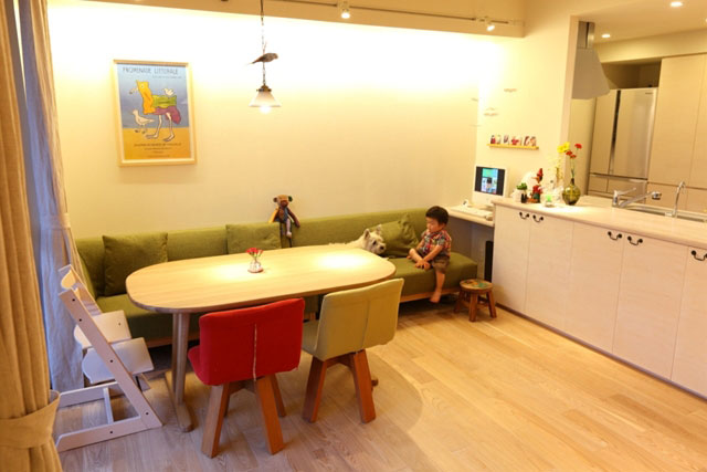 間接照明の光が壁をやさしく照らす。その下のソファーはダイニングチェアーも兼ねています。