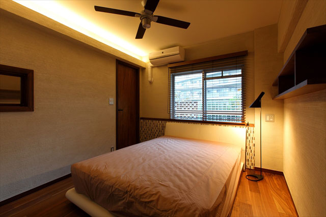 寝室の照明は間接照明とフロアランプのみ。モザイクタイルを貼ったヘッドボードがアクセントになっています。