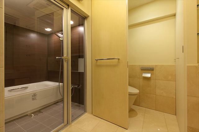 ユニットバスとトイレ。居住スペースとは一変して大理石とオフホワイトの壁、ホテルライクなコーディネート。