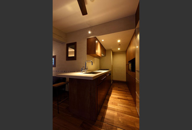 機能的なキッチンは、リビングと比べ明るめの照度を確保。奥は洗濯機スペース、一時的な物干しスペースも完備。