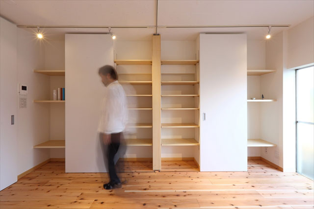 壁面収納は、間仕切りカーテン収納を中心にシンメトリーで構成。テレビを置くスペースも二ケ所確保。