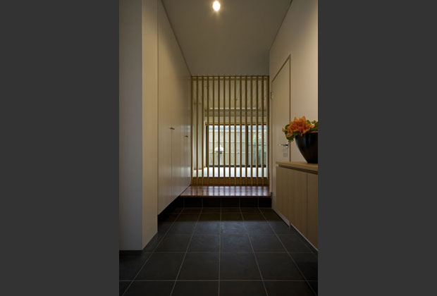 玄関は大容量のもの入れを設置。格子の先から坪庭を望めます