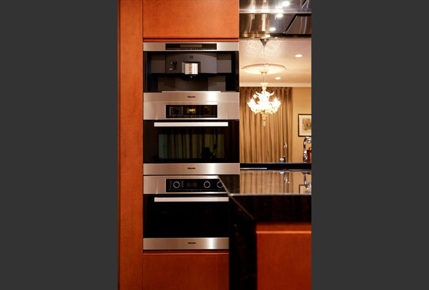 ドイツ・ミーレ社の機器が並ぶ壁面キッチン収納、最上段はご主人のエスプレッソマシーン。