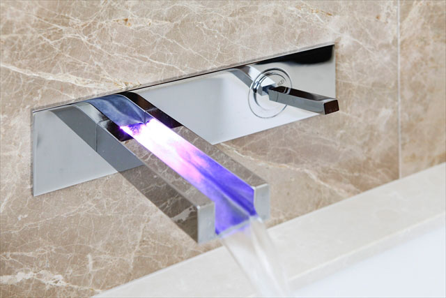 サニタリー手洗いは壁から流れ出るような水栓を採用。水温でライトの色が変化します。