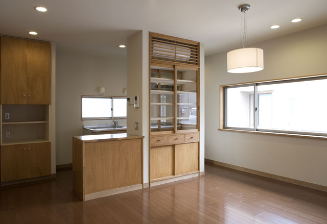 両面から使える食器棚が、キッチン周りの目隠しに。木製ルーバーでエアコンも目立ちません。