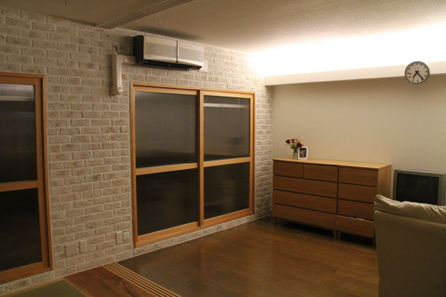 断熱と目隠しを兼ねた木製の2重サッシは、レンガ壁と共に外部的雰囲気を演出