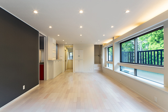 白を基調とした明るい部屋に濃いグレーのアクセント壁