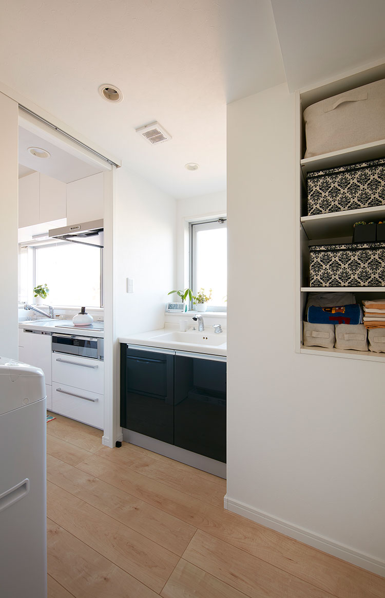 窓際に配置した洗面台とシステムキッチン。構造上制約がある間取りを工夫して新設したこの開口部によって回遊性が生まれ、家事動線が改善された